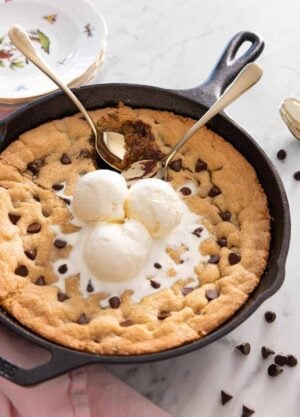 A skillet cookie with three scoops of ice cream on top.