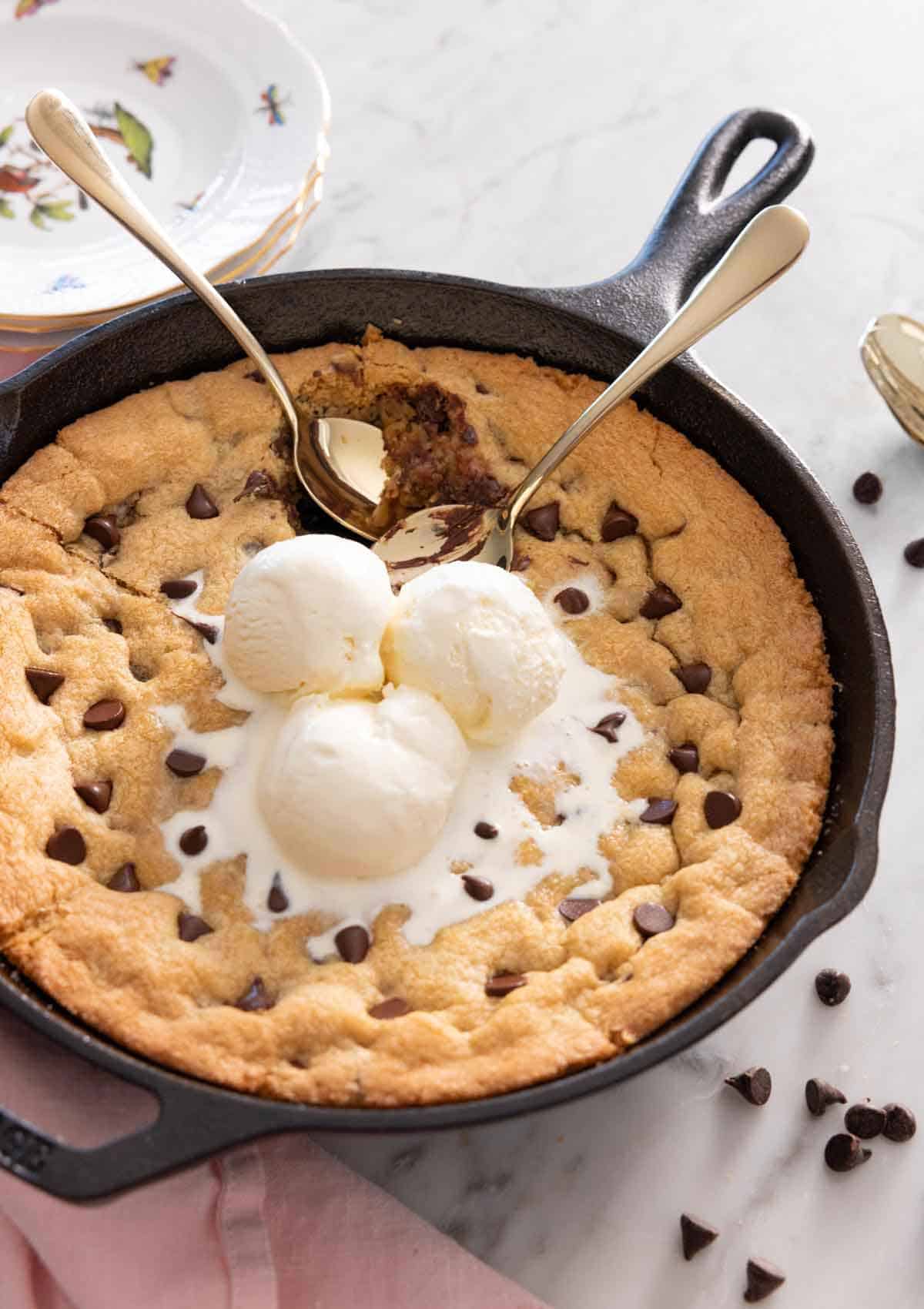 A skillet cookie with three scoops of ice cream on top.