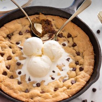 Pinterest graphic of a skillet cookie with ice cream scooped on top and two spoons digging in.