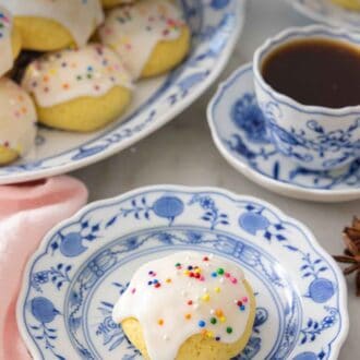 Pinterest graphic of a plate with an anise cookie in front of coffee and a platter.