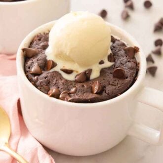 A brownie in a mug with a scoop of ice cream on top.
