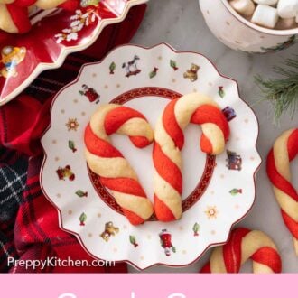 Pinterest graphic of a plate with two candy cane cookies.
