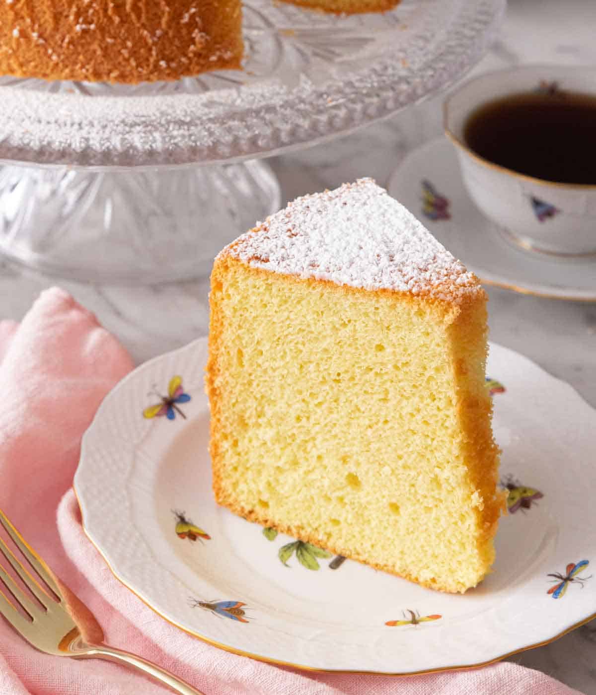 A slice of chiffon cake on a plate with powdered sugar on top.