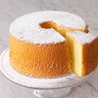 A chiffon cake on a cake stand, dusted with powdered sugar.