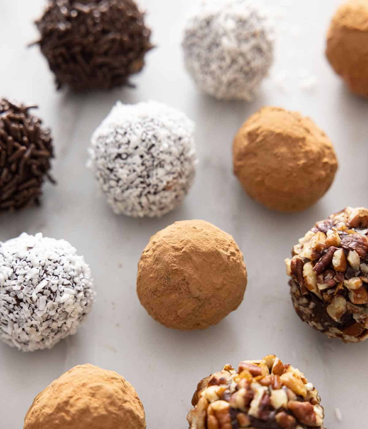 Rows of chocolate truffles with different coatings on them.