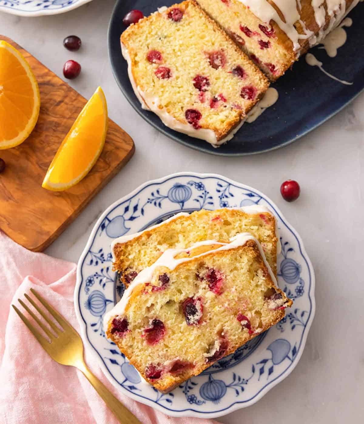 Overhead view of a plate with two slices of cranberry orange bread.
