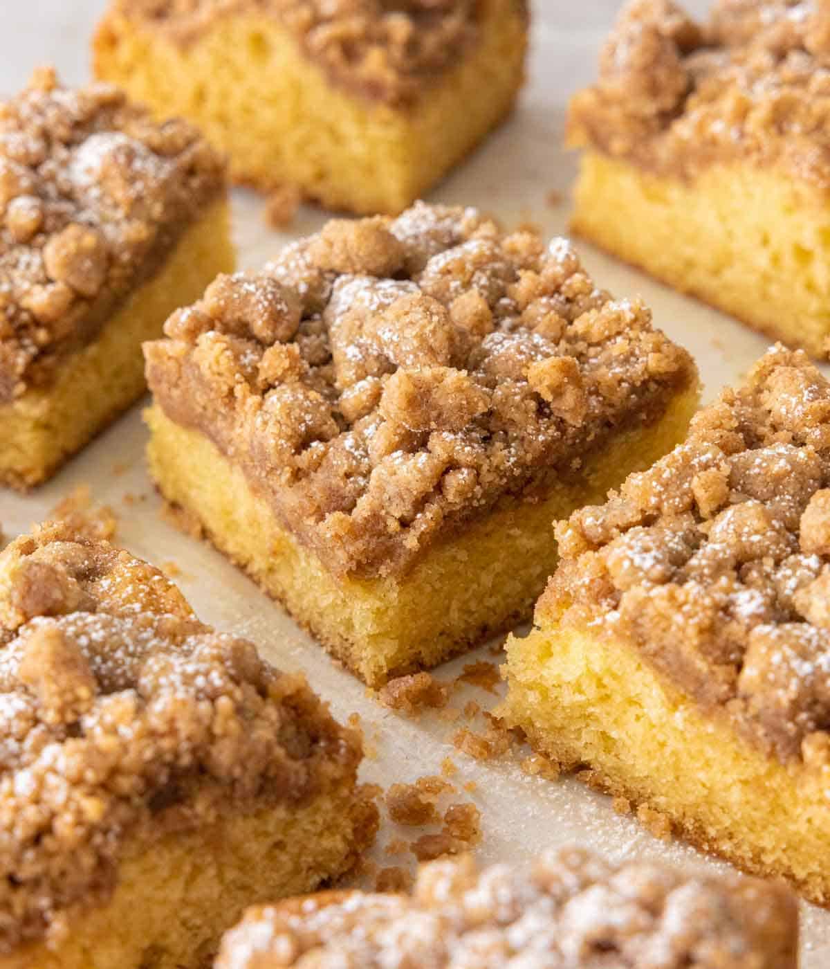 Square slices of crumb cake scattered on a counter.