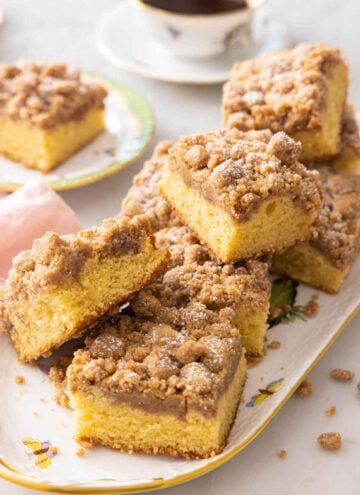A platter of square pieces of crumb cake.