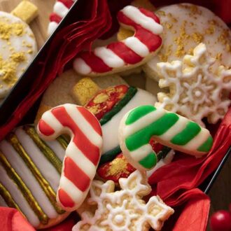 A box with multiple cookies decorated like ornaments, candy canes, and snow flakes.