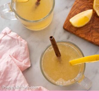 Pinterest graphic of an overhead view of two glasses of hot toddies.