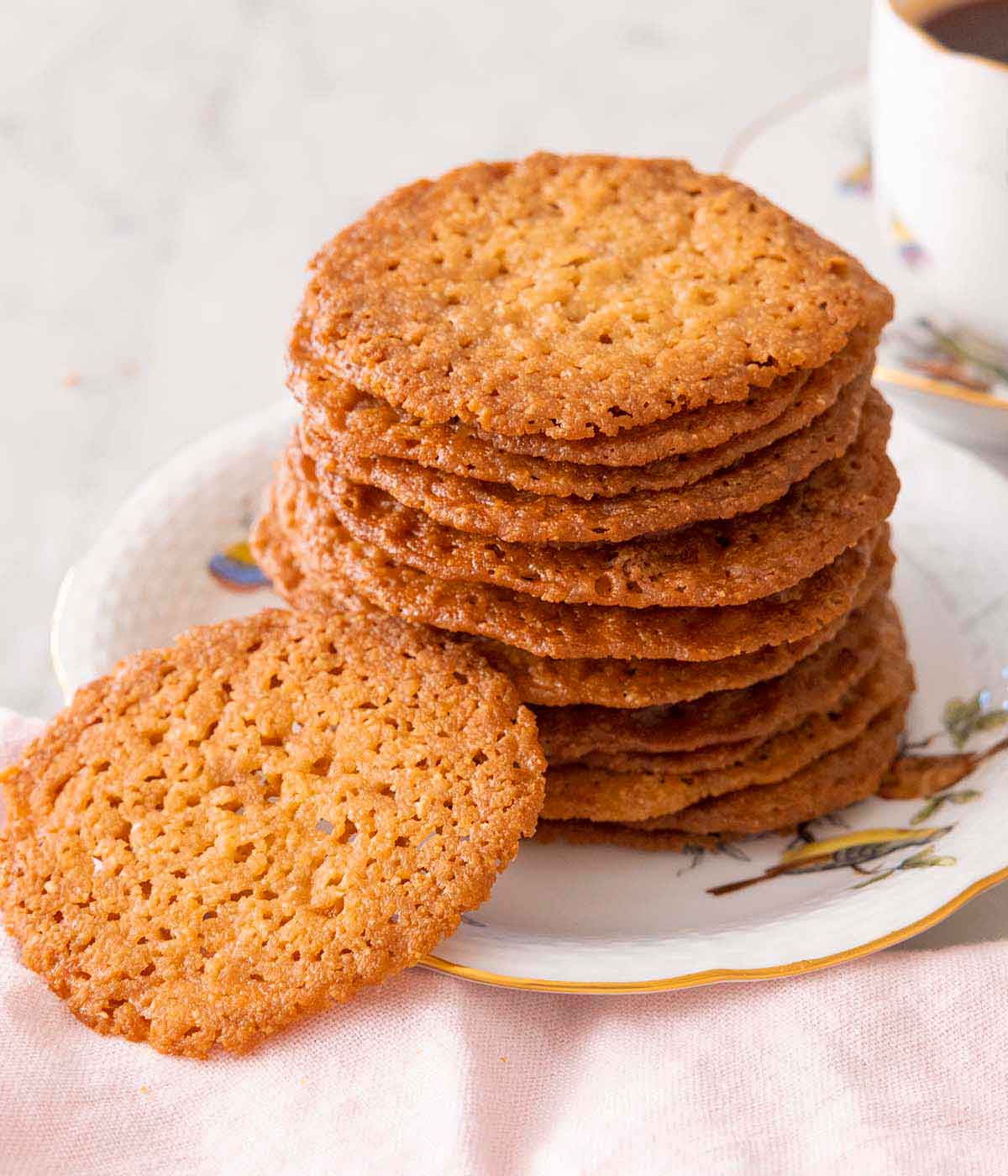 A stack of lace cookies with one in front.