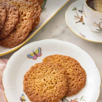 Pinterest graphic of a plate with two lace cookies in front of a platter.