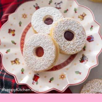 Pinterest graphic of a plate with three linzer cookies.