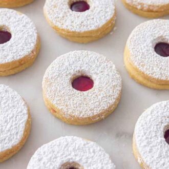 Linzer cookies in a single layer on a flat surface.