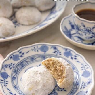 Pinterest graphic of a plate with two Mexican wedding cookies, one with a bite taken out.