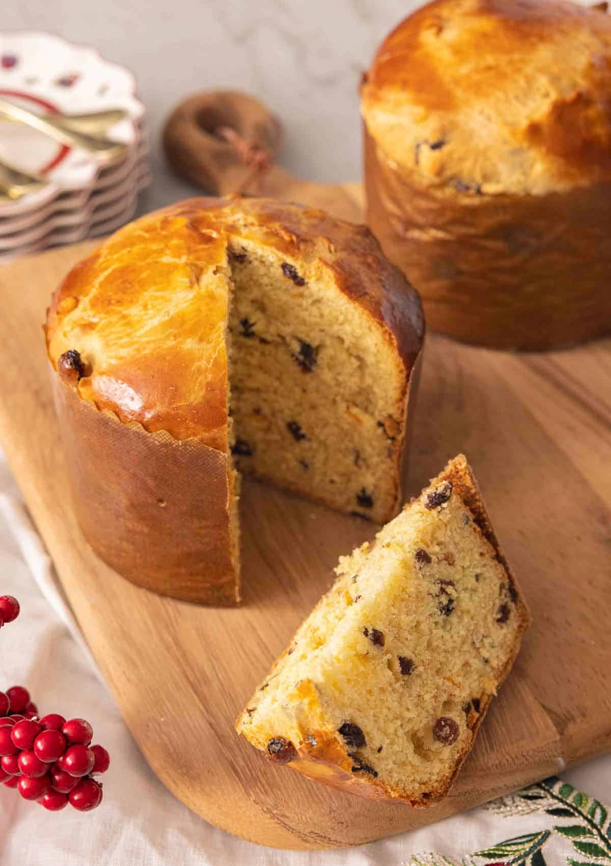 A loaf of panettone with a slice cut out on a cutting board.