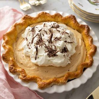 A peanut butter bliss pie with whipped topping and shaved chocolate on top.