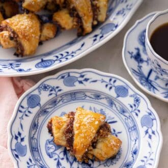 Pinterest graphic of a plate with a rugelach by some coffee and a platter.