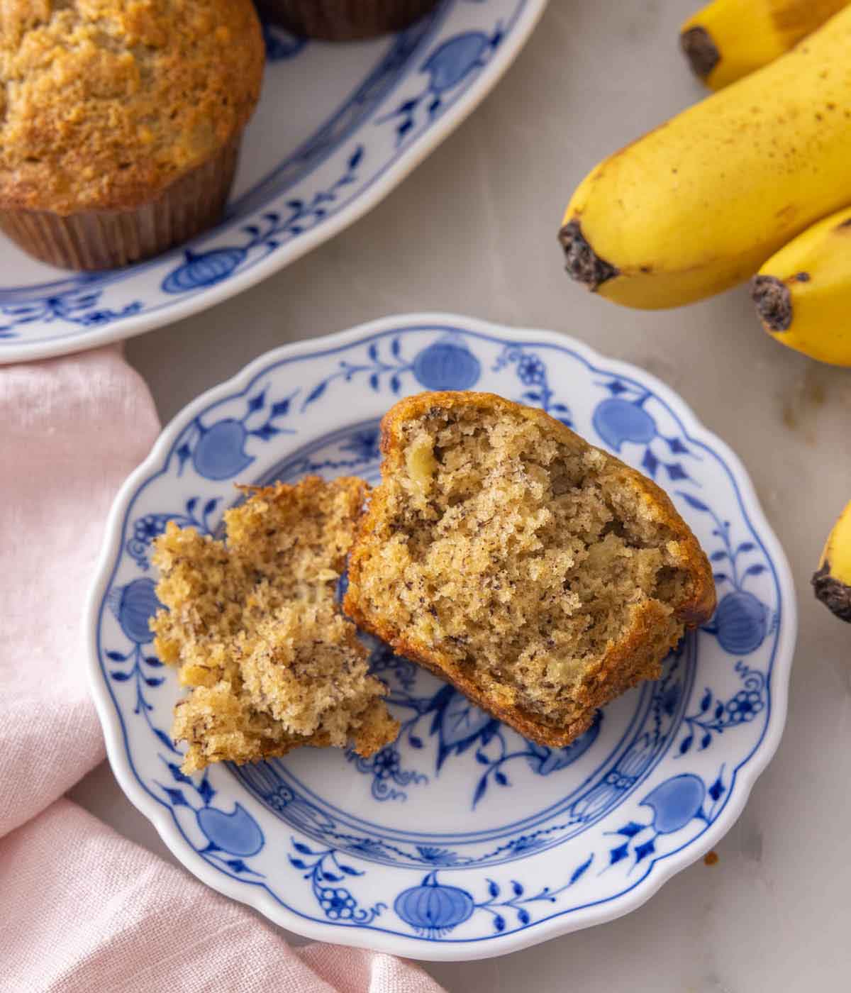 A plate with a banana muffins torn in half to show the cross section.