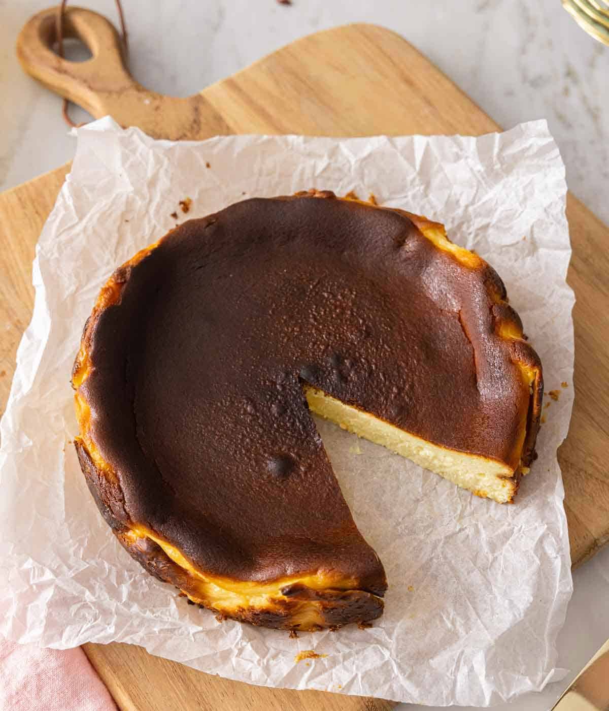 Overhead view of a basque cheesecake with a slice cut out.