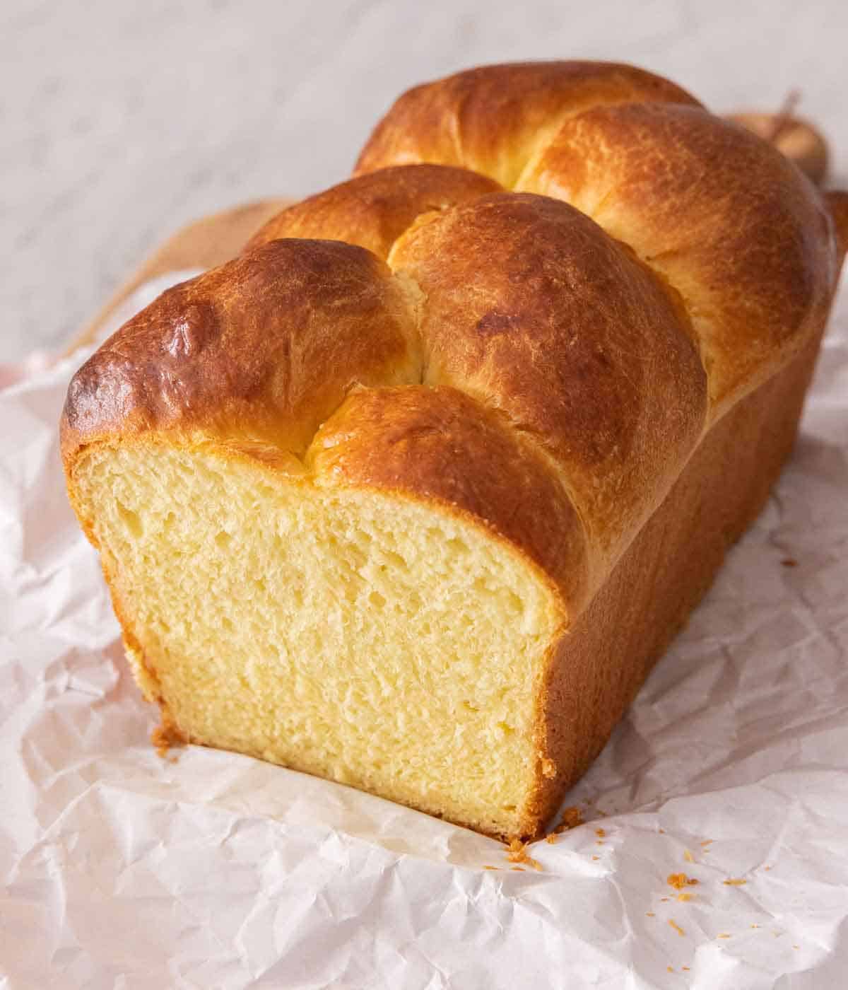 A loaf of brioche bread on parchment paper.