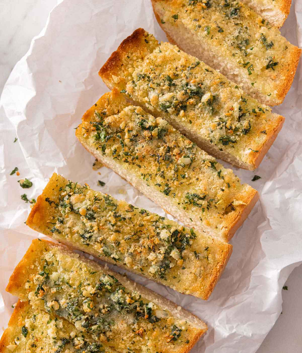 Overhead view of a loaf of garlic bread, cut into rectangles.