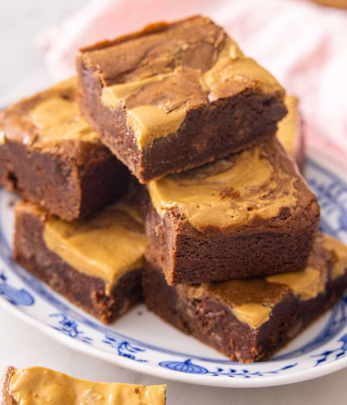 A plate with a pile of peanut butter brownies.