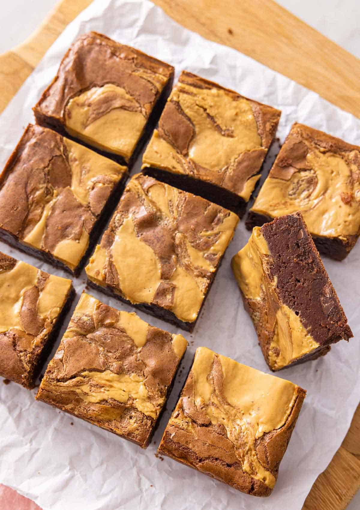 A cutting board of peanut butter brownies cut into 9 servings.