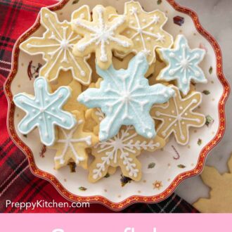 Pinterest graphic of a festive plate of a pile of snowflake cookies.