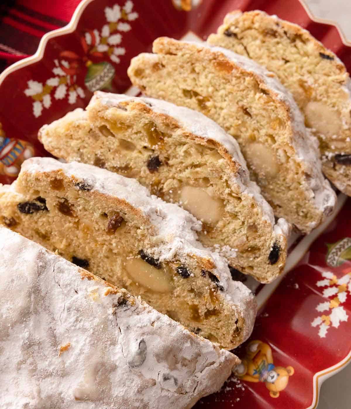 A loaf of stollen, sliced, showing the inside dotted with rum soaked fruit.