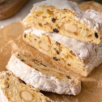 Pinterest graphic of a loaf of stollen with three slices cut on parchment paper.