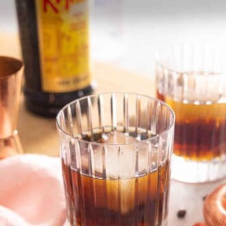 Pinterest graphic of two glasses of Black Russian cocktails with one in front and in focus.