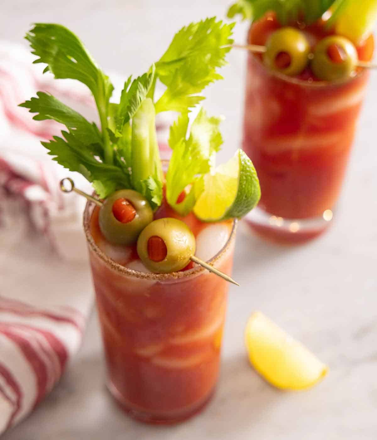 Angled few showing the Bloody Mary's garnishes - olives, lime, and celery.