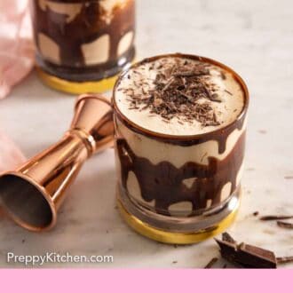 Pinterest graphic of two chocolate coated glasses of mudslide cocktails.
