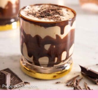 Pinterest graphic of a glass of mudslide with chocolate sauce and shaved chocolate.