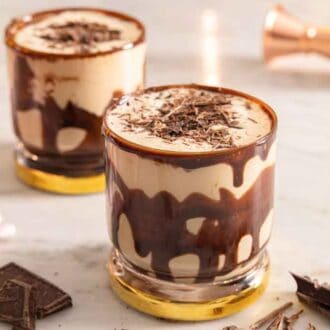 Two glasses of mudslides with chocolate sauce coating the glass.