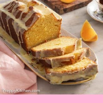 Pinterest graphic of a loaf of orange cake with three slices cut in front.