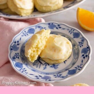 Pinterest graphic of a plate of two orange cookies with one cut in half and propped up.