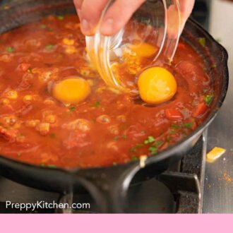 Pinterest graphic of a raw egg being added to a simmer pot of shakshuka.