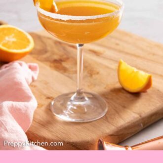 Pinterest graphic of a sidecar with orange garnish on a serving board.