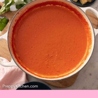 Pinterest graphic of an overhead view of a large pot of tomato soup.