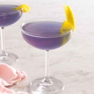 Two Aviation cocktails with lemon twist garnishes.