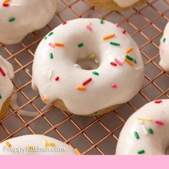 Pinterest graphic of glazed baked donuts with sprinkles on a wire rack.