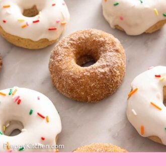 Pinterest graphic of multiple baked donuts with some glazed with sprinkles.