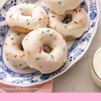Pinterest graphic with a platter of glazed baked donuts with rainbow sprinkles on top.