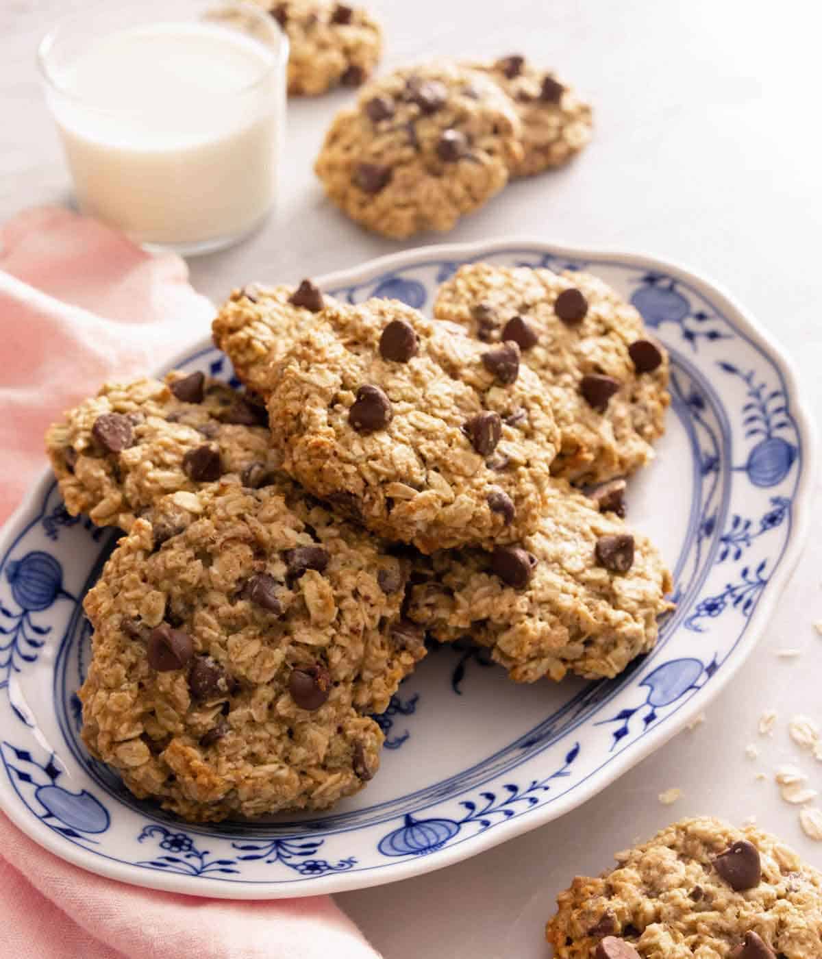 A platter of banana oatmeal cookies by a cup of milk.