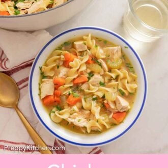 Pinterest graphic of a bowl of chicken noodle soup by a glass of wine.