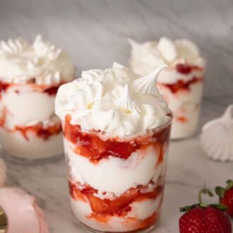 Pinterest graphic of three glasses of Eton mess with one in front with strawberries on the side.