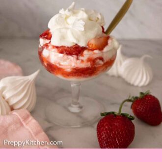 Pinterest graphic of a glass of Eton mess with meringues and strawberries by it.