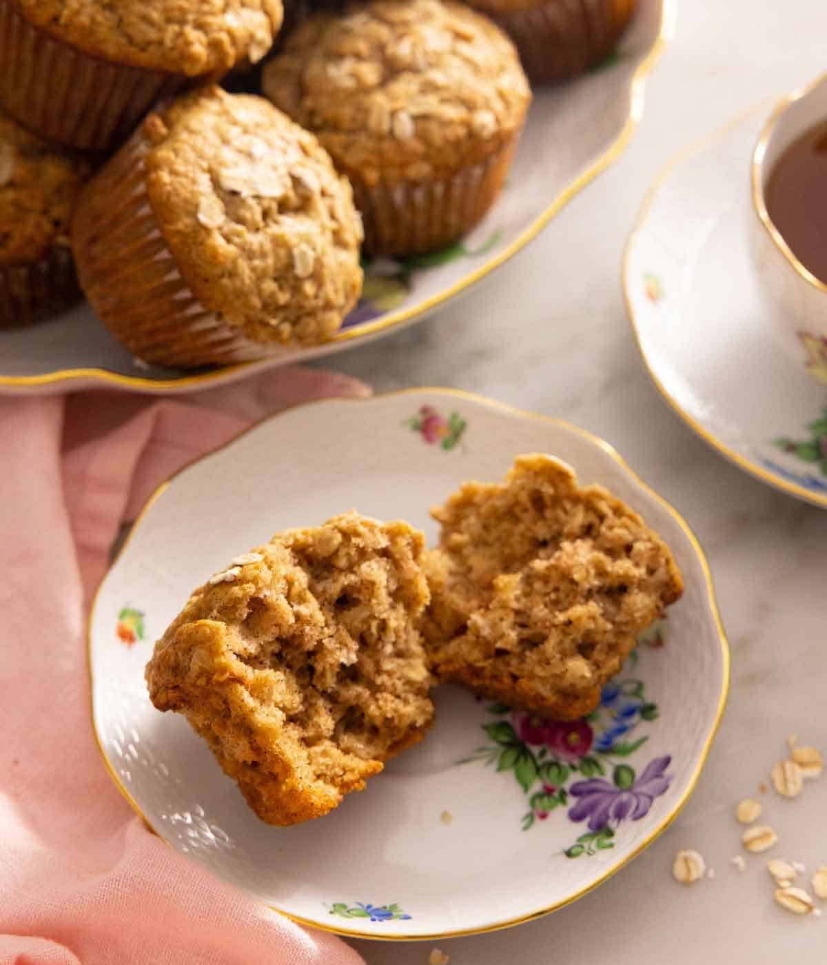 A plate with a oatmeal muffin, torn in half.